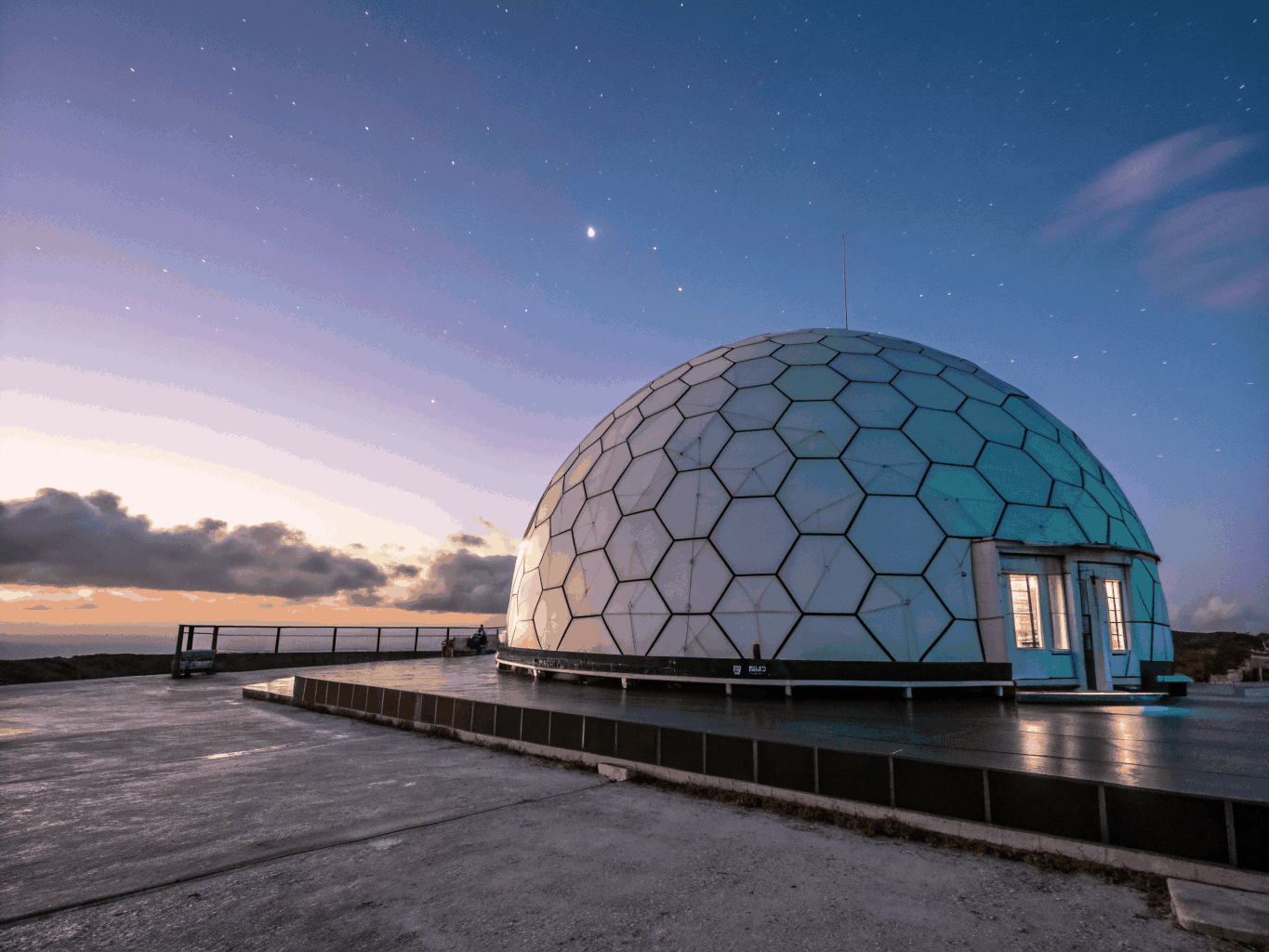 Illuminated geodesic dome structure situated in a cold outdoor environment